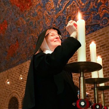 Schwester zündet Kerze an